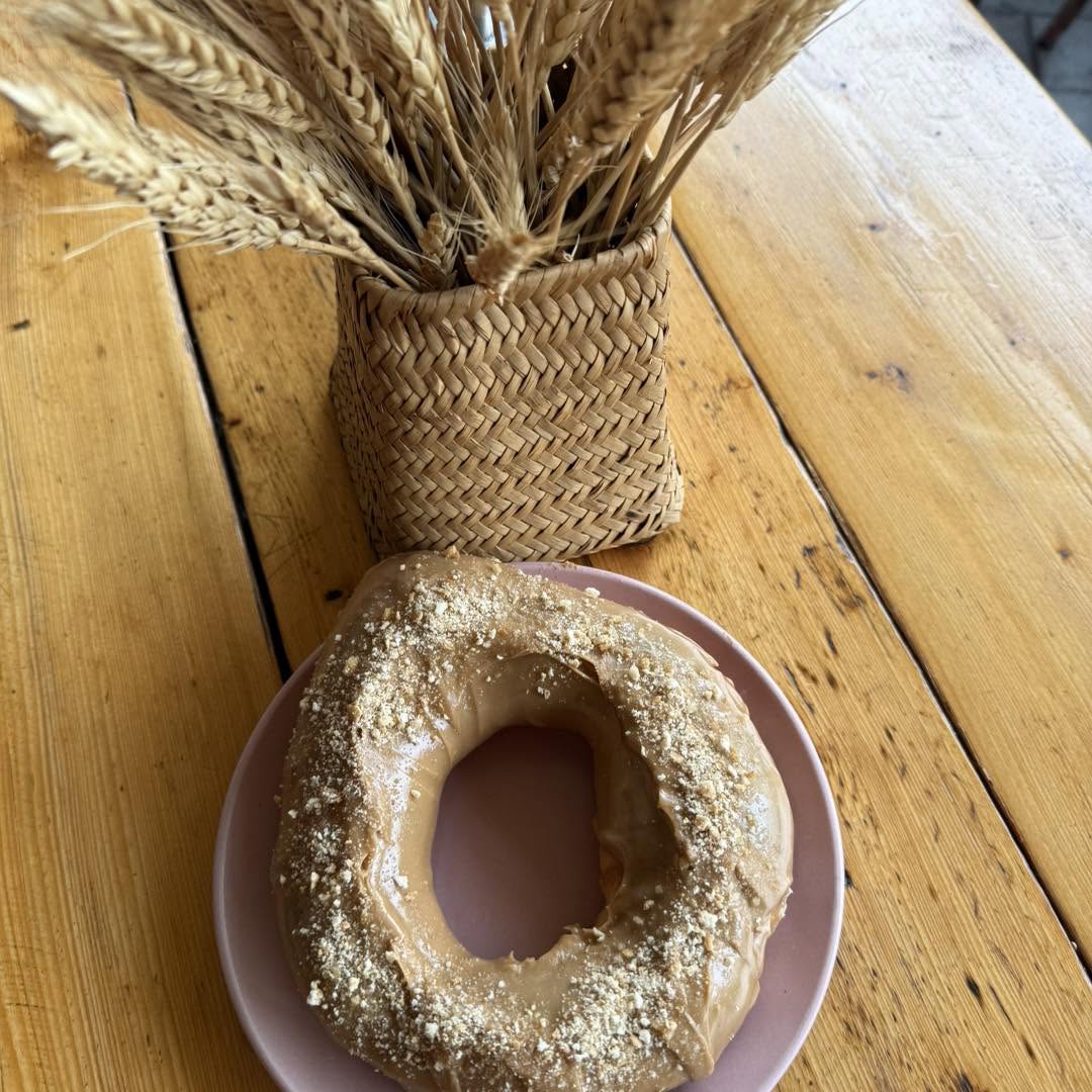 A real Pretzie Biscoff pretzel on a plate beside a wheat arrangement